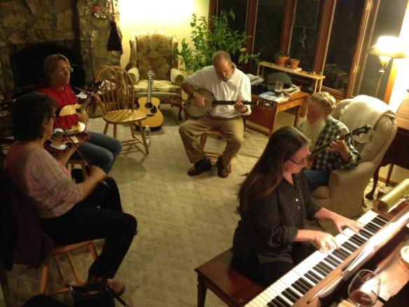photo of old-time musicians playing banjo, mandolin, fiddle, and piano in the living room